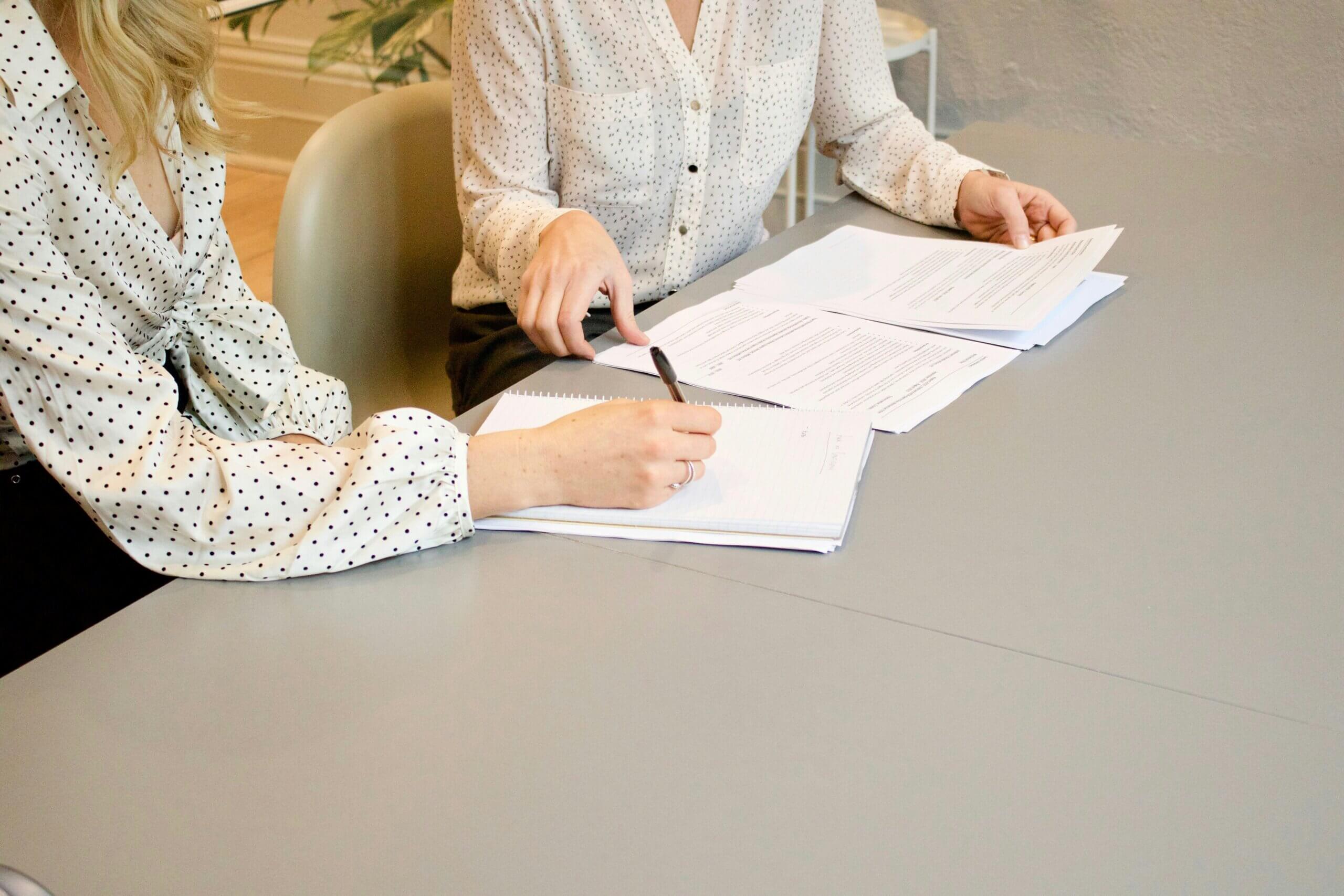 2 people writing on a paper